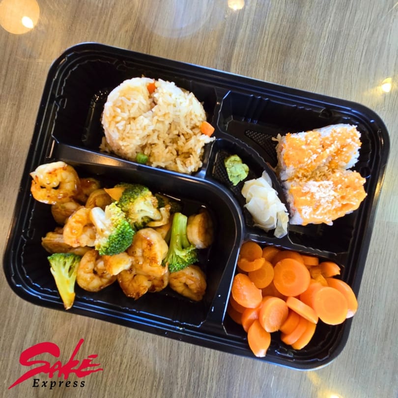 Sake Express bento box with shrimp, broccoli, fried rice, sushi, carrots, wasabi, and ginger.